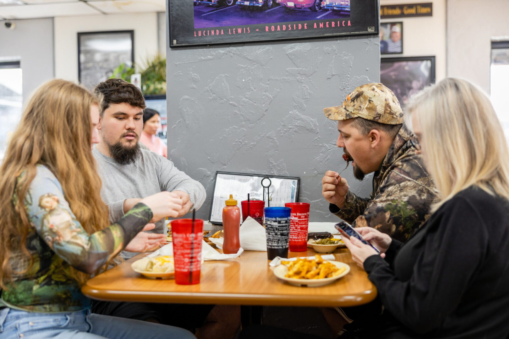 A group of people sitting at a table eating food.