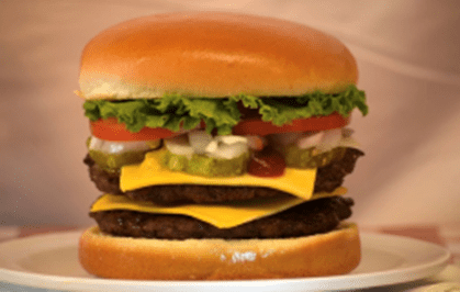Burgerweezscafe A hamburger with cheese, tomatoes and lettuce.